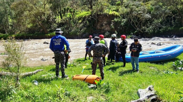 Policías y bomberos en el río Paute, en donde localizaron un cuerpo sin vida el 23 de mayo de 2024.