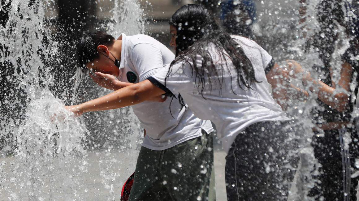 Personas se refrescan en la fuente de un parque en México, 23 de mayo de 2024.