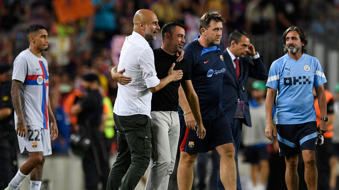El técnico español del Manchester City, Pep Guardiola (i), abraza al técnico español del FC Barcelona, el 24 de agosto de 2022.