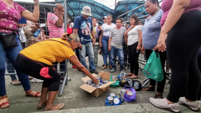 Familiares de personas privadas de la libertad donan latas de atún en las afueras de la Penitenciaría del Litoral, en el norte de Guayaquil, este lunes 3 de junio del 2024.