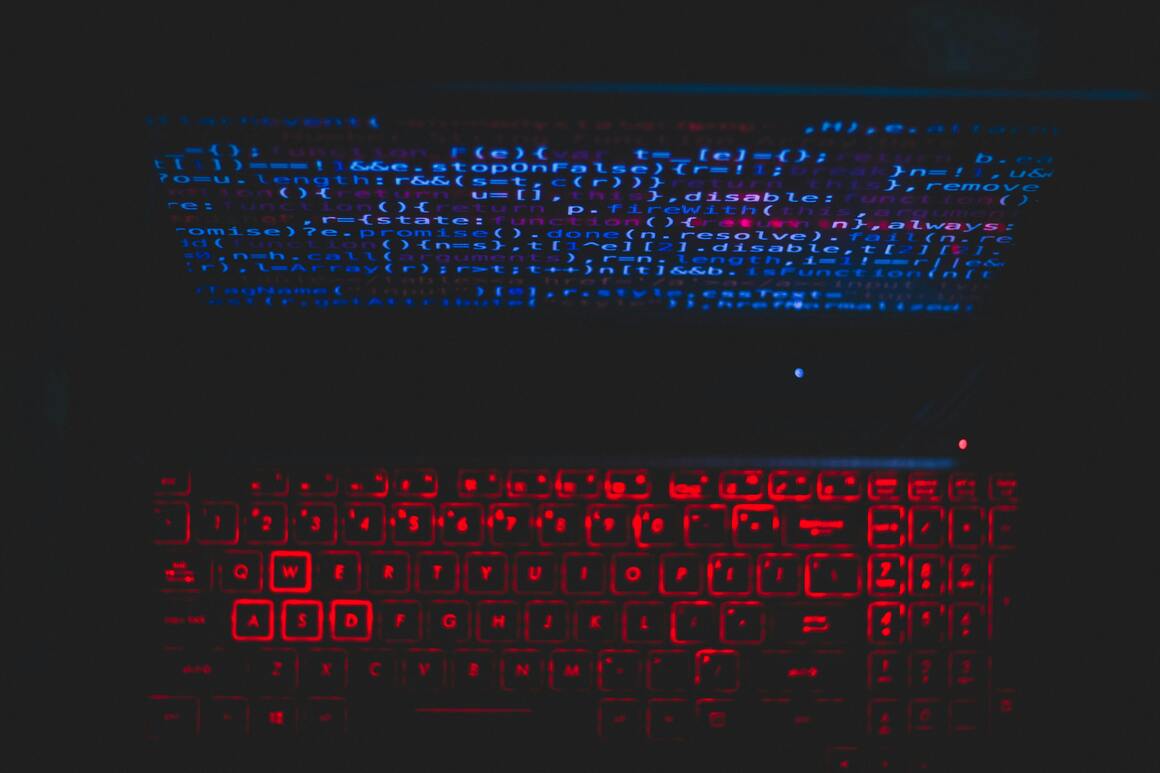 Imagen referencial de una computadora con texto de programación en la pantalla.