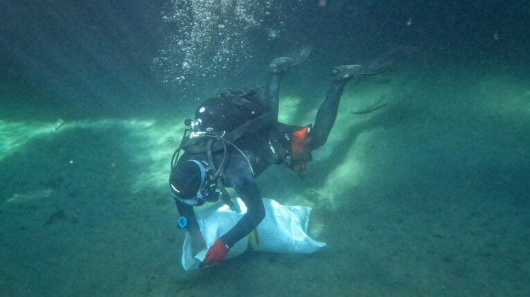 Un voluntario recoge basura en el fondo del mar en Grecia, en el día mundial de los océanos, en noviembre de 2022.