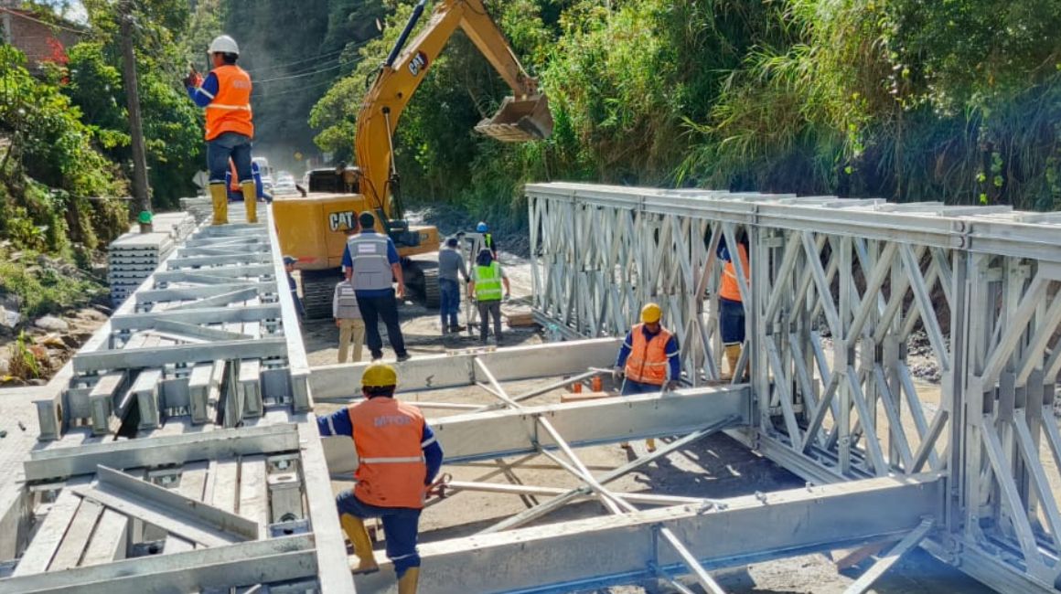 Obreros del Ministerio de Transporte y Obras Públicas trabajan en la colocación del puente Bailey en la vía Baños-Puyo, el 27 de junio de 2024.