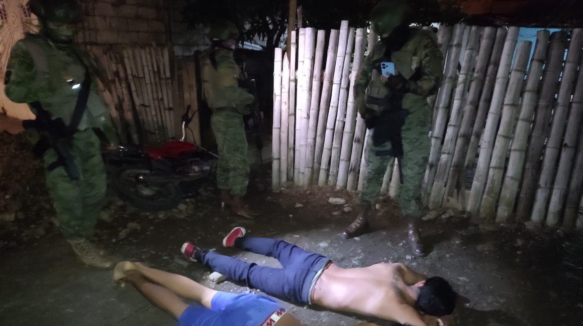 Militares revisan el celular de un sospechoso en Quevedo, la madrugada del 19 de junio de 2024.
