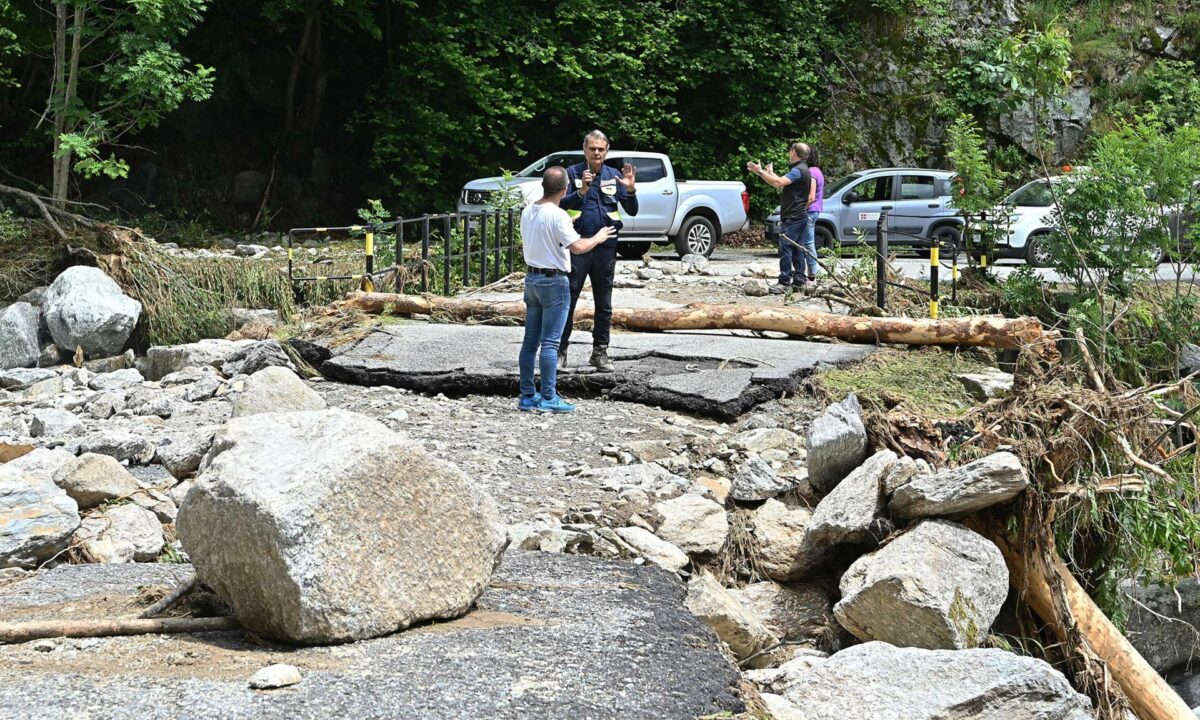 Personas observan un área dañada por las inundaciones y deslizamientos en Chialamberto, en el Valle de Lanzo, al norte de Italia, el 30 de junio de 2024.