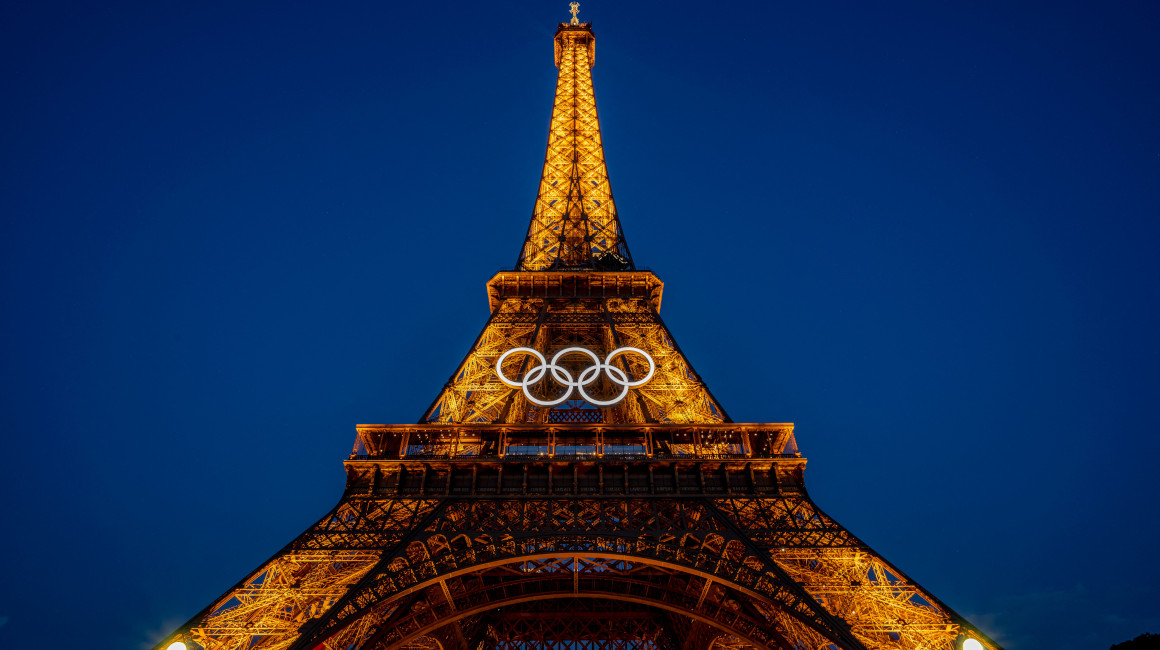 La Torre Eiffel ilumnada por la noche junto a los anillos olímpicos, el 26 de junio de 2024.